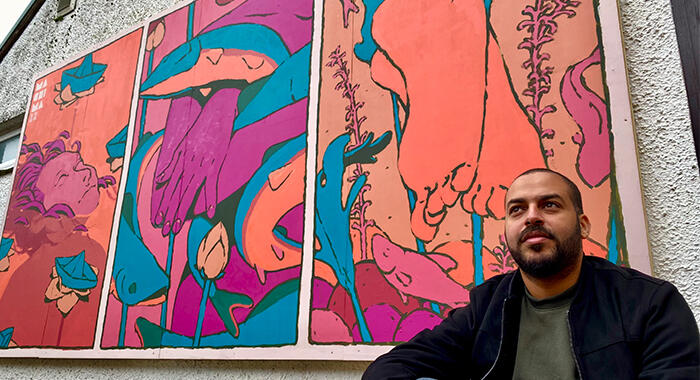 Mehdi Annassi with the Windermere Arctic Charr mural on the Lake District Boat Club for LICAF 2022